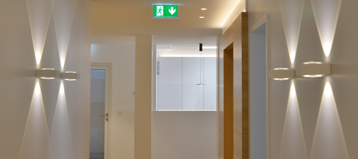 Lichtdurchfluteter Flur mit hellen Farben und modernem Ambiente – Blick zum Empfangsbereich der Praxis.